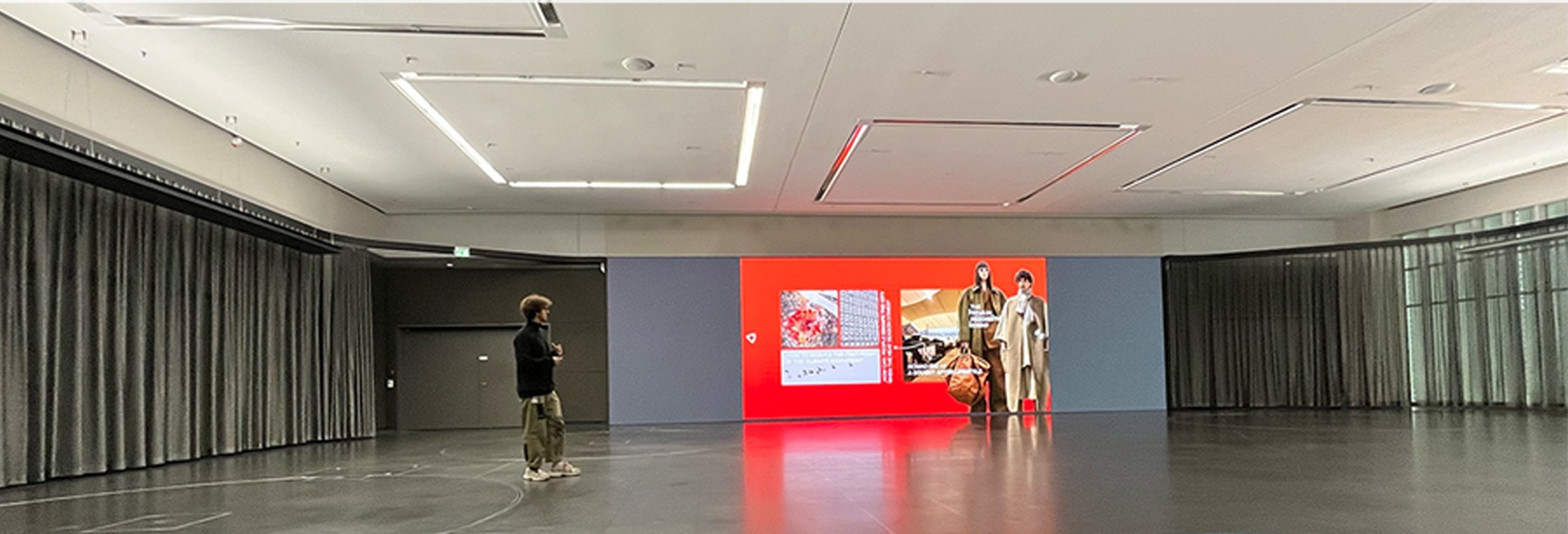 Presentation space with a visitor viewing a red BMW Oasis Roof Pod display