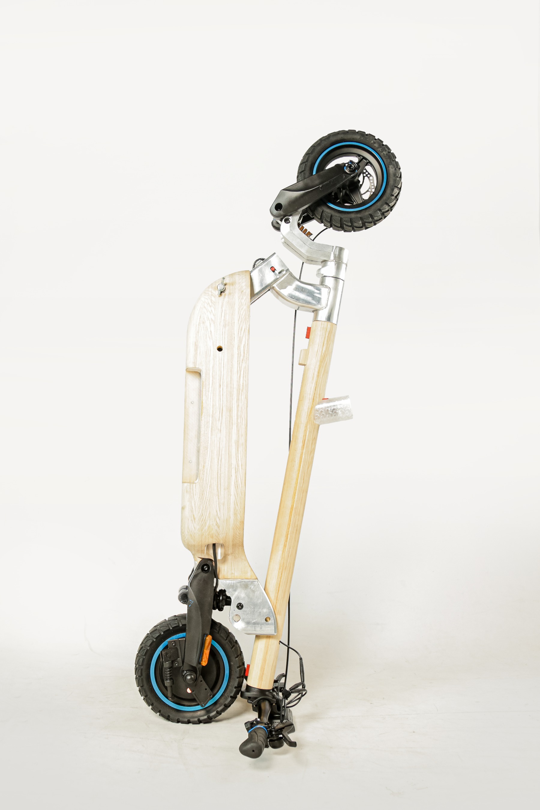 Folded scooter standing upright, front wheel and deck visible