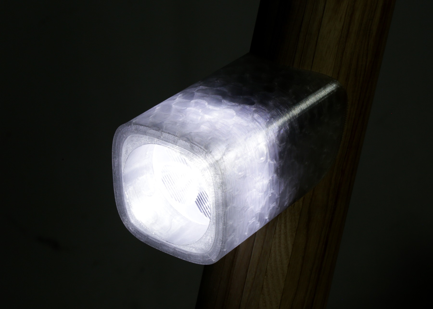 Close detail of the front light module mounted on the wooden neck