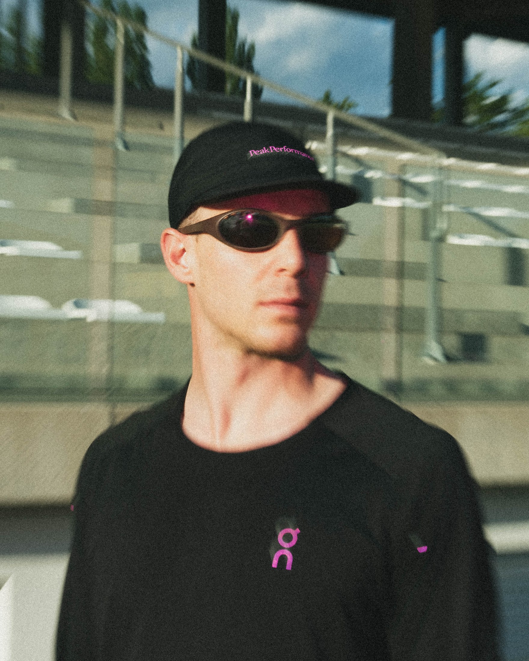 Lifestyle portrait wearing the frame with a cap, outdoor stadium setting