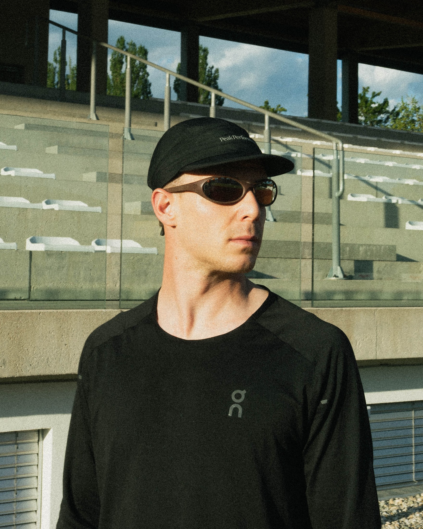 Lifestyle portrait wearing the frame, alternate angle, outdoor stadium setting
