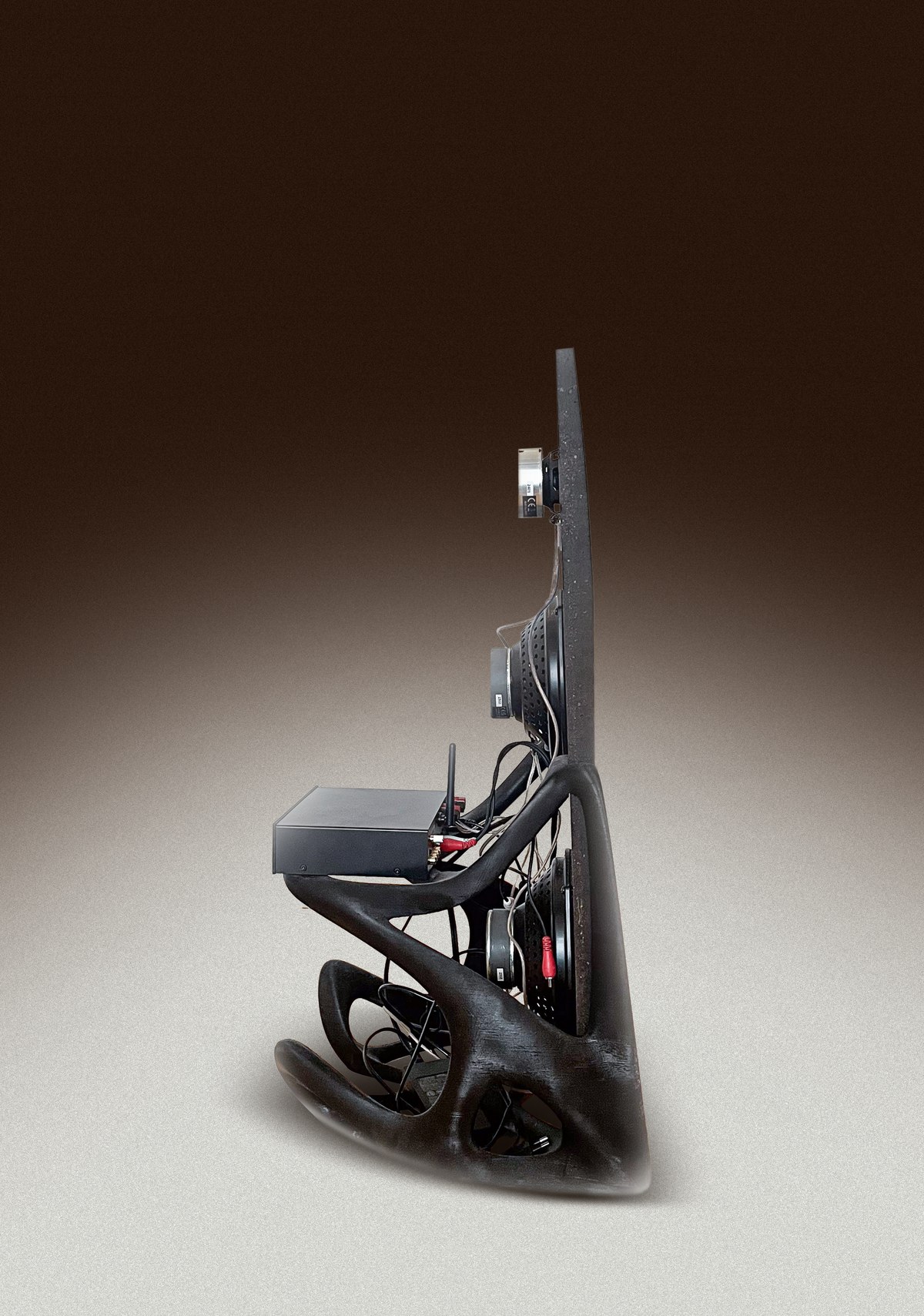 Sculptural black stand with speaker component and wiring, side profile
